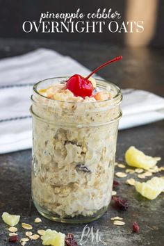 a jar filled with overnight oats on top of a table next to sliced bananas and cherries