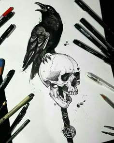 a drawing of a skull with a crow on it's head next to pens and markers