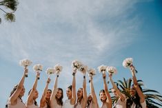 a group of bridesmaids holding bouquets in the air