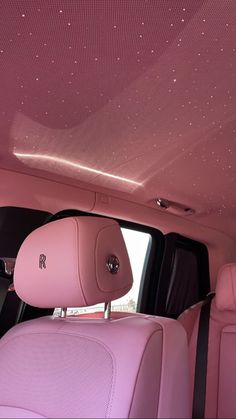 the interior of a car with pink leather seats and diamond embellishment on the ceiling