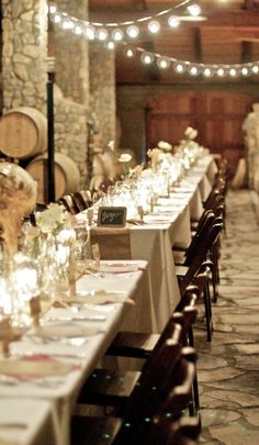 a long table is set up with wine glasses and candles for an elegant wedding reception