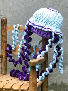 a crocheted hat sitting on top of a wooden chair