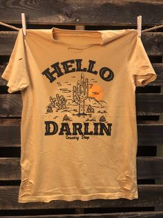 Country Deep Hello Darlin 80's country western unisex Distressed Vintage T shirt available in white and mustard and Green 40 Singles Jersey 100% Cotton Premium quality ringspun and compacted cotton Fine Cotton Jersey that is pigment dyed for a more vintage look Features tears and destroyed features at neck and on body Each piece is unique as this process is done by hand! 3.8 oz Made In USA Every garment dye item can be a slightly different shade in color since this is a laundry dye process. Enjo 80s Country, Hello Darlin, Distressed T Shirt, Country Western, Vintage Look, Vintage Tshirts, Vintage Looks, Mustard, Shirt Designs