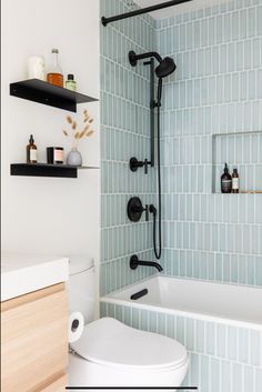 a white toilet sitting next to a bath tub under a shower faucet in a bathroom