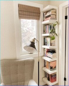 a room with a chair, lamp and bookshelf in it's corner