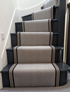 the carpeted stairs are lined with black and white rugs