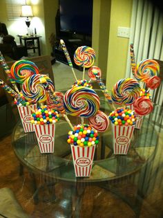 there are many lollipops on the glass table in this living room and it looks like they're ready to eat