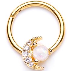 a gold plated ring with an opal and white stone in the middle, on a white background