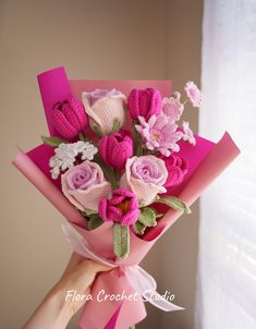 a person holding a bouquet of pink and white flowers