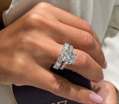 a close up of a person wearing a ring on their finger and holding a book