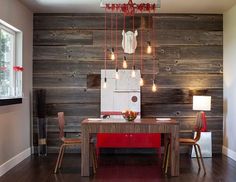 a dining room with wood paneling and red accents