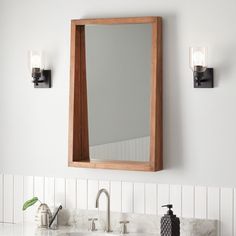 a bathroom sink with a wooden mirror above it