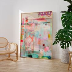 an abstract painting in a frame on the wall next to a chair and potted plant