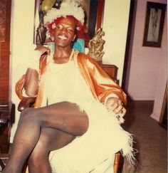 a woman sitting in a chair with her legs crossed and wearing tights on the floor