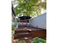 an outdoor deck with steps leading up to the patio area and trees in the background