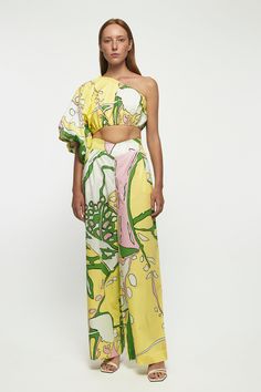 DESCRIPTION Exaggerated One Shoulder Crop - USD 269.00 This printed cropped top will effortlessly take you from the beach to golden hour on vacation. Cut from airy cotton, a romantic sleeve cascades from the one-shoulder neckline and sways in the sea breeze. Style yours with the matching pants. * Prints and colours may vary slightly due to the handmade nature of each piece. Color: Metamorphosis V Front Straight Leg Trouser - USD 279.00 These sorbet printed pants have such a relaxed feel. They're Spring Vacation Wide Leg Sets, Chic Printed Summer Crop Top, Yellow Wide Leg Summer Sets, Yellow Wide Leg Sets For Summer, Cropped Sets For Spring Vacation, Spring Vacation Cropped Sets, Chic Printed Crop Top For Vacation, Summer Printed Wide Leg Sets, Spring Beachwear Crop Top For Day Out