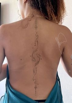 the back of a woman's body with tattoos on it