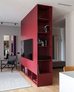 a living room with a large red book shelf