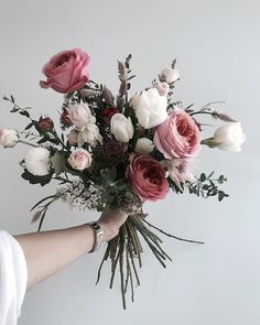 a person holding a bouquet of flowers in their hand