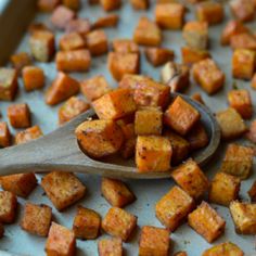 a wooden spoon full of cubed sweet potatoes