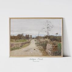 a painting hanging on the wall next to a white wall with an old road and trees