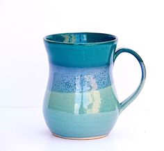 a blue and green coffee mug sitting on top of a table