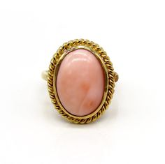 -  Presented is a lovely 18 karat yellow gold and coral ring. This is a relatively  contemporary piece, but the style is reminiscent of antique coral rings, very  elegant. The ring is set with a beautiful oval cabochon of peachy pink coral  inside a ropetwist border. The coral cabochon measures about 15.7 by 11.3  millimeters.  This ring is stamped and guaranteed 18k (750=18k), as well as a maker's mark  of AJF.  This ring is in excellent condition. The coral is well set with no chips.  The ring Elegant Oval Coral Rings, Elegant Coral Oval Rings, Elegant Oval Coral Jewelry, Elegant Coral Oval Jewelry, Oval Coral Cabochon Jewelry, Coral Oval Cabochon Jewelry, Coral Rings, Mixed Metal Bracelets, Art Nouveau Ring