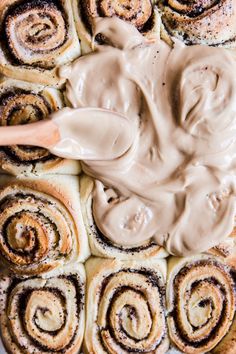 a pan filled with cinnamon rolls covered in icing and topped with chocolate frosting