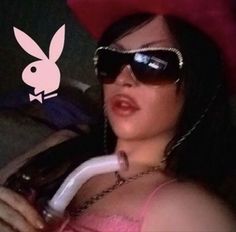 a woman wearing sunglasses and a pink hat with bunny ears on it's head