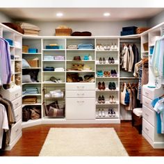 an organized closet with white shelves and drawers