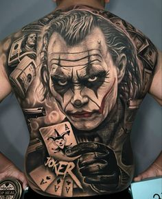 a man with a tattoo on his back that has the joker and money in it