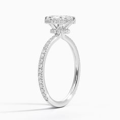 a white gold ring with diamonds on the sides and an oval shaped center stone in the middle