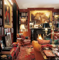 a living room filled with furniture and bookshelves next to a painting on the wall