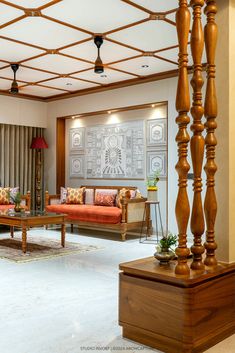 a living room filled with lots of furniture and wooden poles in front of a window