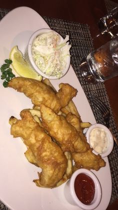 fried food on a white plate with dipping sauces