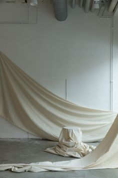 an empty room with white sheets on the floor