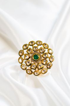 Rinni I - Emerald Finger Ring w/ Meenakari work & Kundan Stones Handcrafted Indian bridal finger ring made with hammered metal and plated with gold. Luxurious emerald stone sits at the centre along with the Kundan stone setting making this ring jewelry one of a kind. Gorgeous floral design Kundans adorns this piece adding grace. A stunning green Meenakari outline enhances this piece making it perfect to be paired with any of your ethnic wear. Stone Setting: Emerald, Kundan & Meenakari Finish: Go Gold Meenakari Rings For Festive Occasions, Gold Rings With Meenakari For Festive Occasions, Festive Gold Ring With Meenakari Detail, Gold Ring With Stone Work, Gold Jeweled Open Ring Jewelry, Festive Gold Ring With Meenakari, Gold Fusion Style Ring Jewelry, Gold Jeweled Wedding Rings, Gold Kundan Rings In Temple Jewelry Style