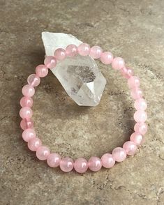 Rose Quartz 6mm Beaded Gemstone Bracelet on a crystal. Rose Quartz Jewelry Bracelets, Forms Of Love, Power Of Forgiveness, Rose Quartz Bracelet Beads, Girly Bracelets, Love And Compassion, Bracelet Craft, Purple Acrylic, Rose Quartz Jewelry