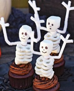 cupcakes decorated with white frosting and skeleton decorations