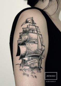 a woman's arm with a ship tattoo on the back of her left arm