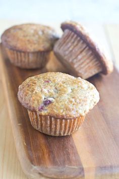 two muffins sitting on top of a wooden cutting board