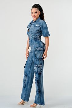 Step into the spotlight with the "Retro Denim Cargo Jumpsuit ," a modern twist on classic utility style tailored for the fashion-forward woman. This jumpsuit merges the comfort and casual cool of denim with the functionality of a workwear-inspired design. The jumpsuit is crafted from a premium denim fabric that offers both durability and a flattering drape. With a nod to vintage fashion, it features a structured collar, cuffed short sleeves, and a button-down front that allows for adjustable cov Summer Denim Jumpsuit With Cargo Pockets, Summer Denim Cargo Jumpsuit, High Rise Denim Jumpsuit With Pockets In Utility Style, High Rise Denim Blue Utility Jumpsuit, Fitted High Waist Denim Jumpsuit In Utility Style, Fitted High Waist Denim Utility Jumpsuit, Fitted Denim Jumpsuit With Pockets, Fitted Denim Jumpsuit Overalls With Pockets, Fitted High-waist Denim Utility Jumpsuit