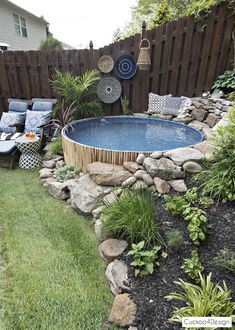 an above ground pool surrounded by rocks and plants