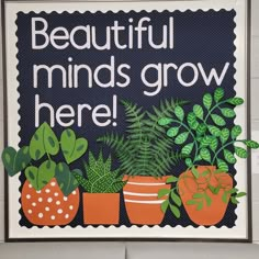 a sign that says beautiful minds grow here with potted plants in front of it