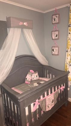 a baby's crib in a room decorated with pink and gray decors