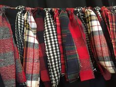 a row of different colored flannel scarves hanging on a line