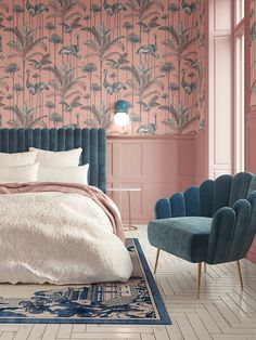 a bedroom with pink walls, blue chairs and a large bed in the middle of it