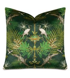 a green pillow with two white birds and palm leaves on it's sides,