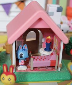 there is a toy house with a bed and toys in the room on the table