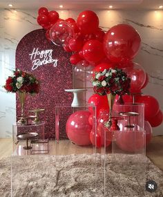 balloons and vases are on display in front of a happy birthday sign with flowers